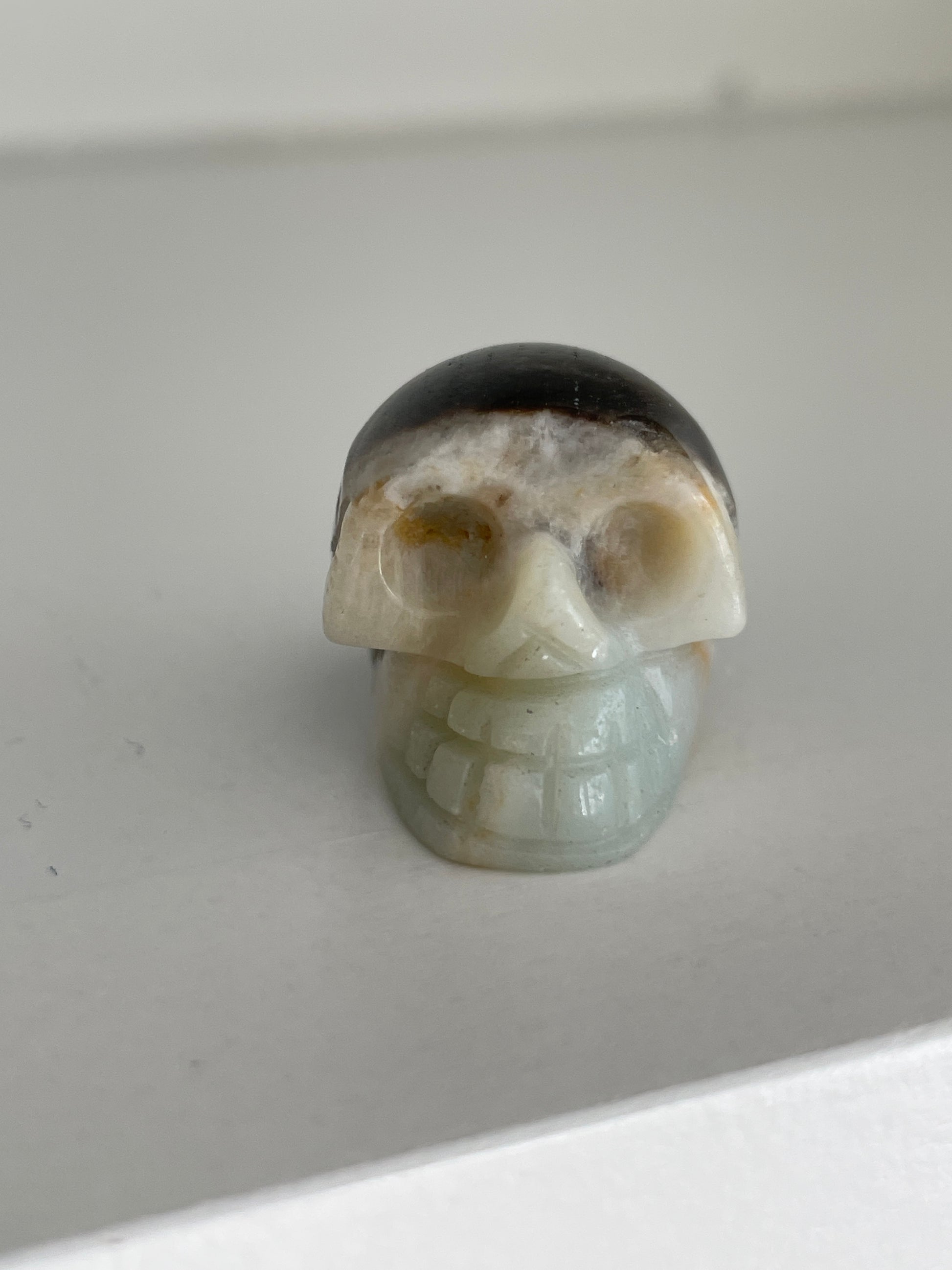 White and brown druzy calcite skull figurine, healing crystal carving.