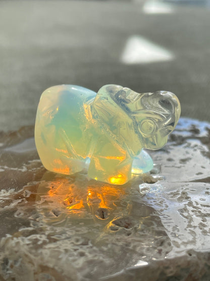 hand-carved opalite elephant figurine glowing with blue and gold hues, spiritual crystal animal totem