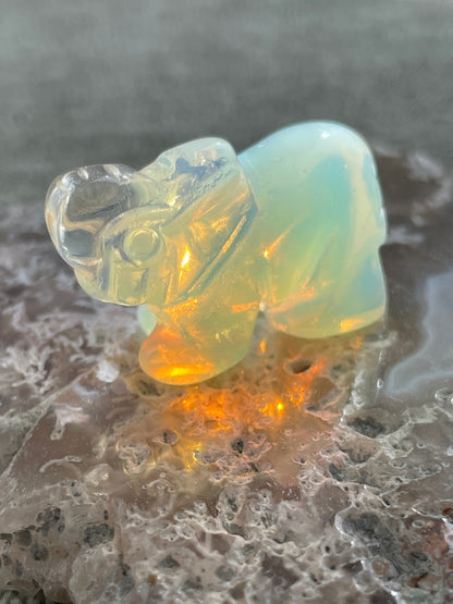 hand-carved opalite elephant figurine glowing with blue and gold hues, spiritual crystal animal totem